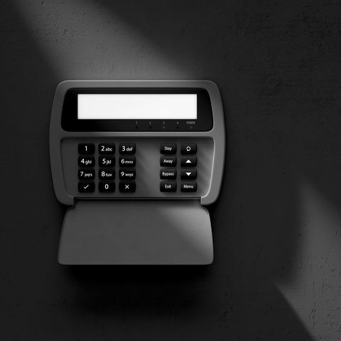 Black time clock with keypad and blank display on a dark background
