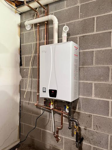 A red and gray boiler with copper pipes coming out of it