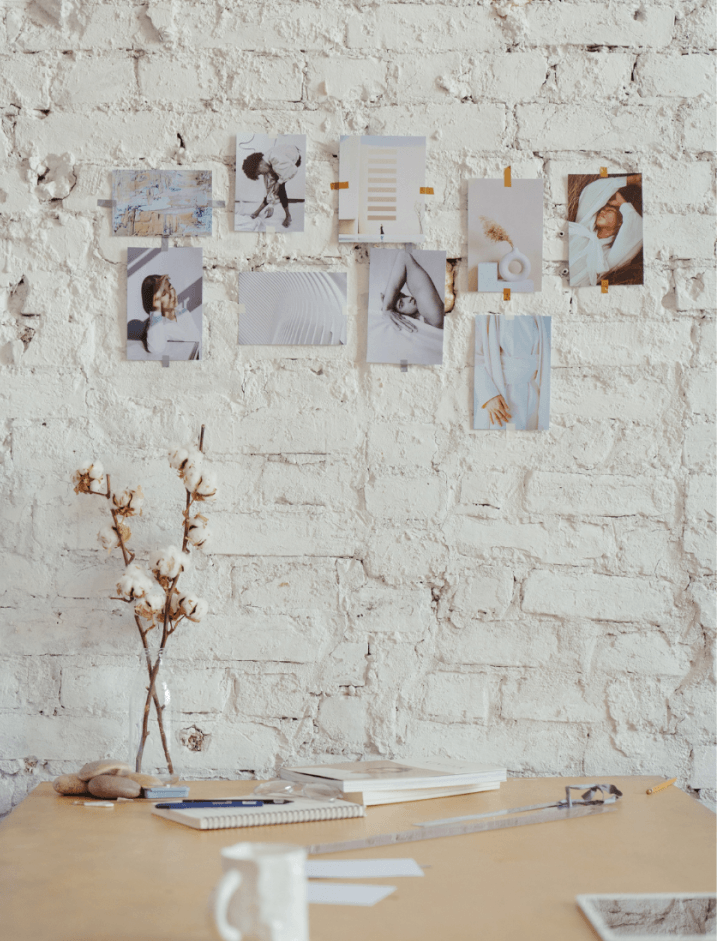 GK Marketing Online | A desk with a vase of cotton flowers on it in front of a white brick wall.