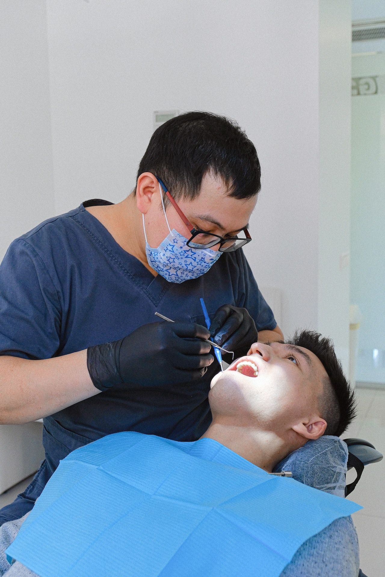A man is getting his teeth examined by a dentist.