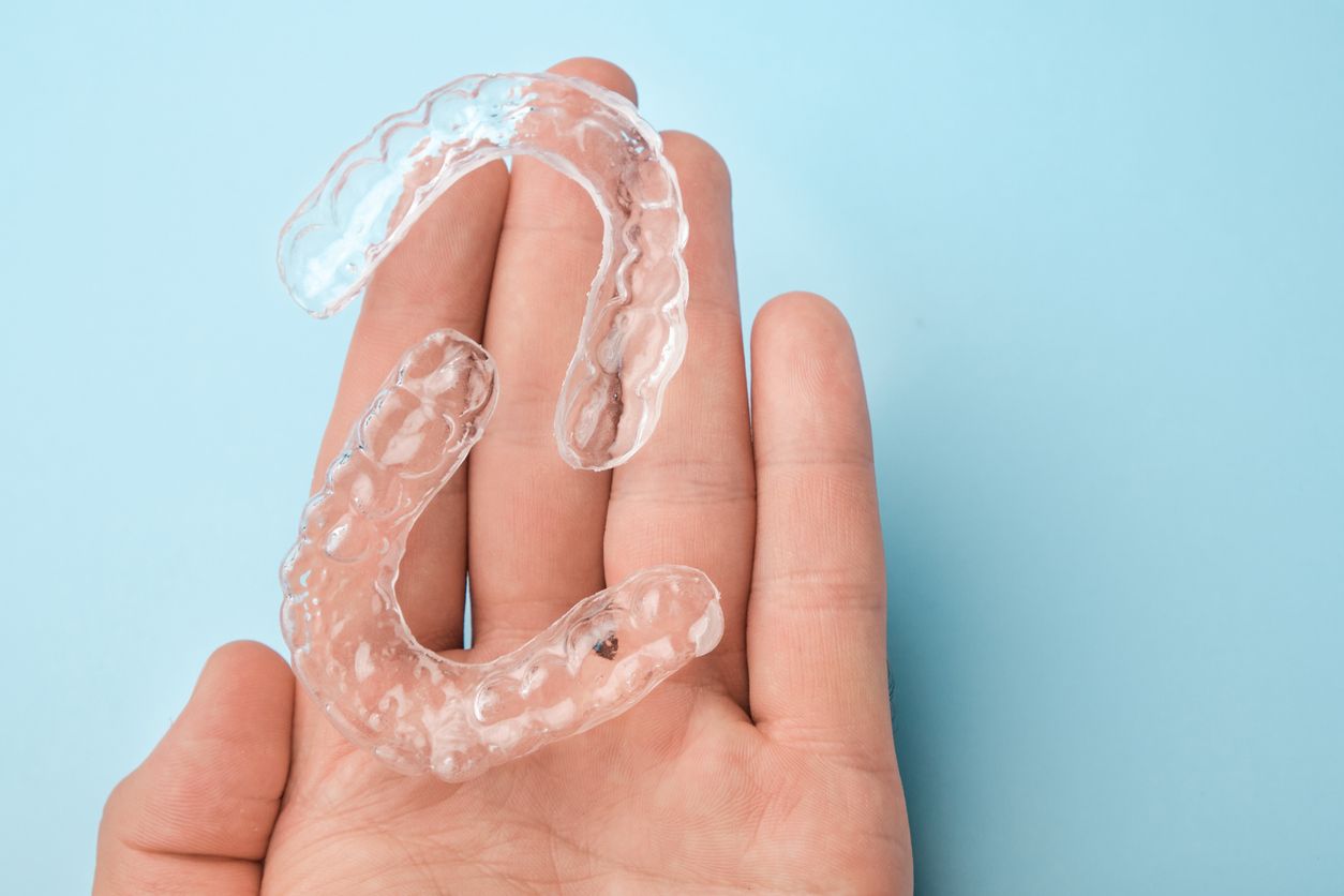 hand holding invisalign clear aligners | Oak Point TX 75068