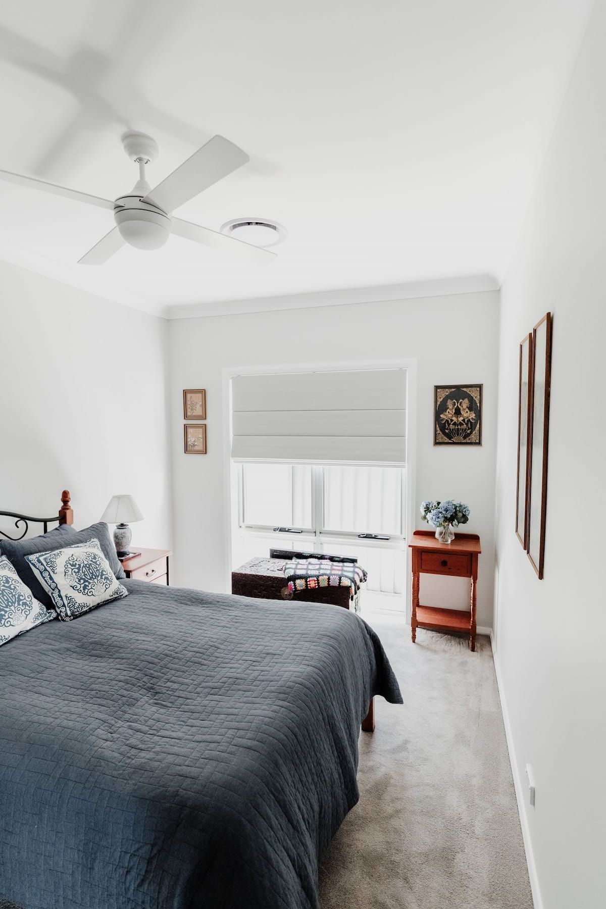 A White Bedroom with Large Bed and Window that has White Roman Blinds — New Blinds and Shutters in Maryland, NSW