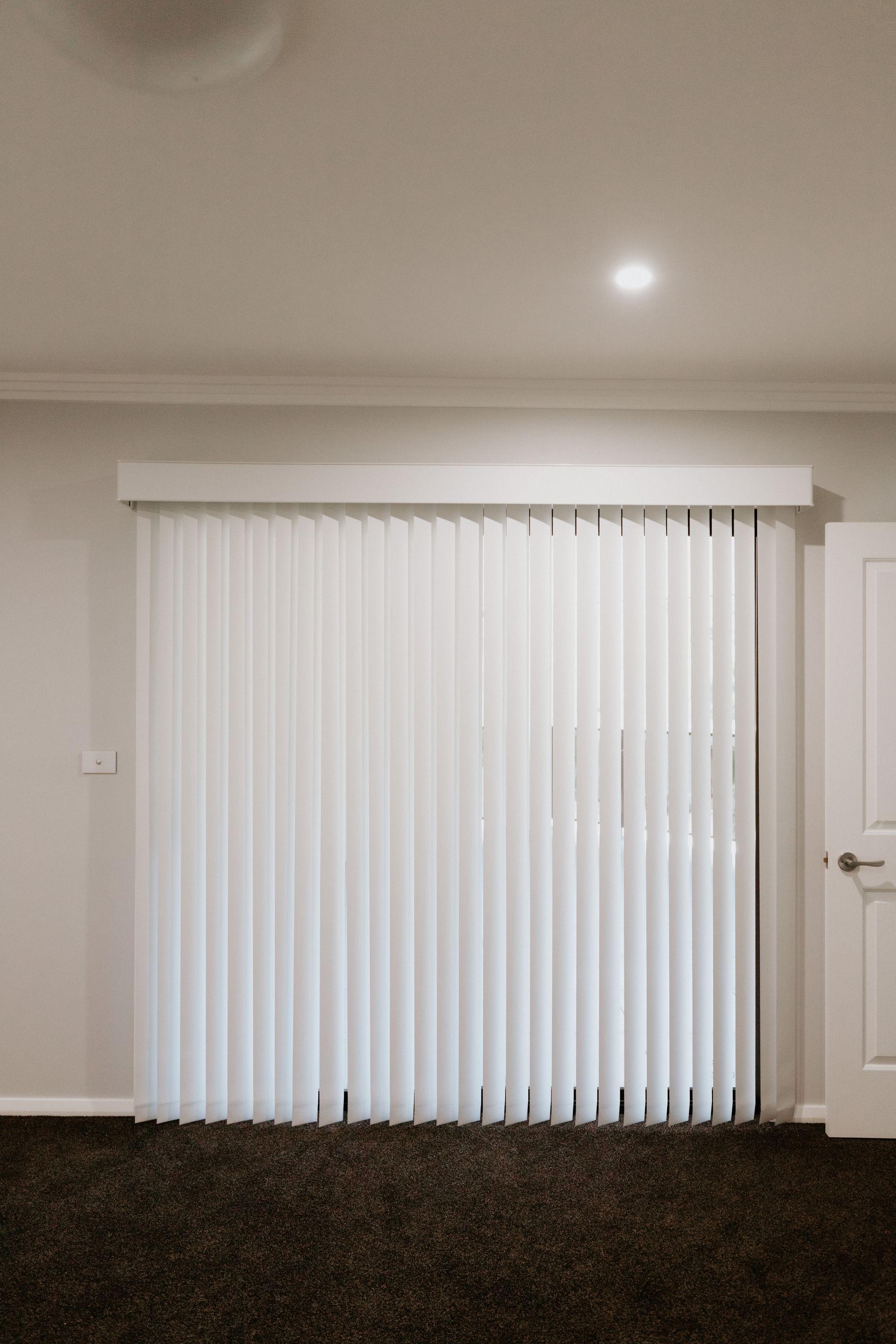 An Empty Room with White Vertical Blinds on The Door —  New Blinds and Shutter in Lake Macquarie, NSW
