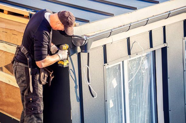 Roofer installing dark seamless gutters