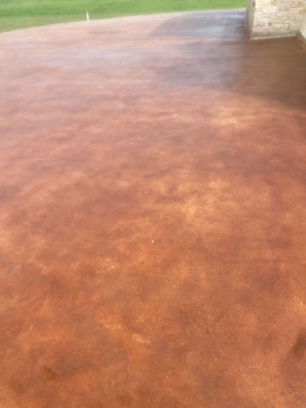 A close up of a concrete floor with a brick wall in the background.