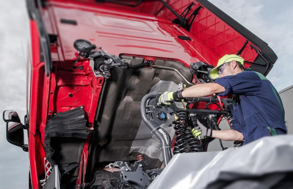 A Man Is Working on The Engine of A Red Truck — Coastal Mechanical Solutions In Albion Park Rail, NSW