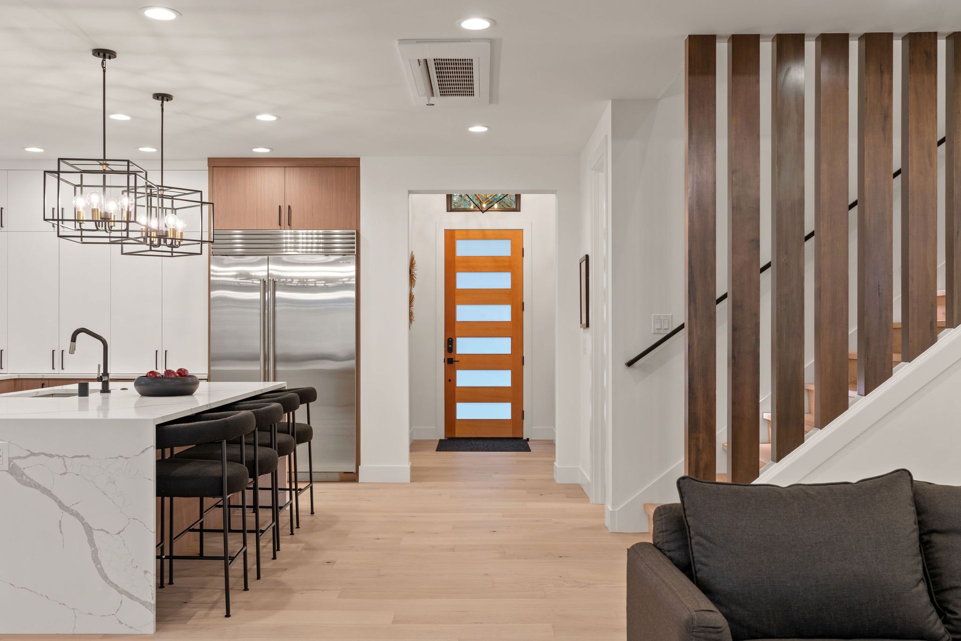 A kitchen with a stainless steel refrigerator and a wooden door.