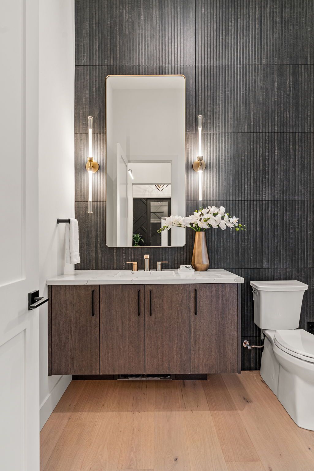 A bathroom with a sink, toilet and mirror.