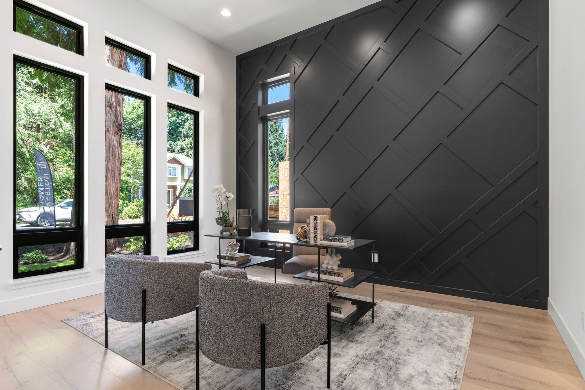 A an office space with a desk and chairs and a decorative black wall.