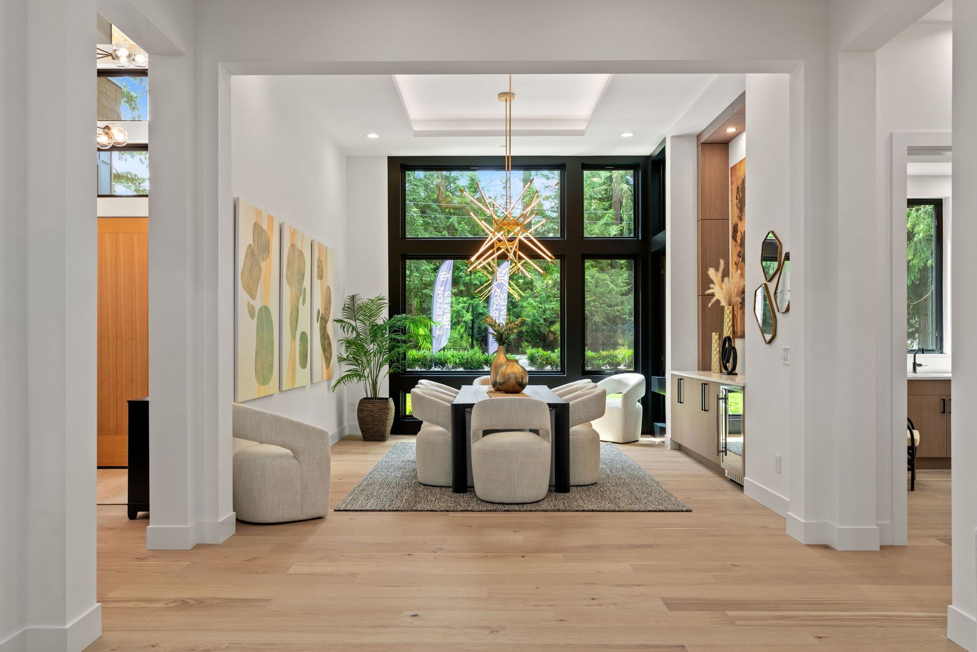 A living room with a table and chairs and a chandelier hanging from the ceiling.