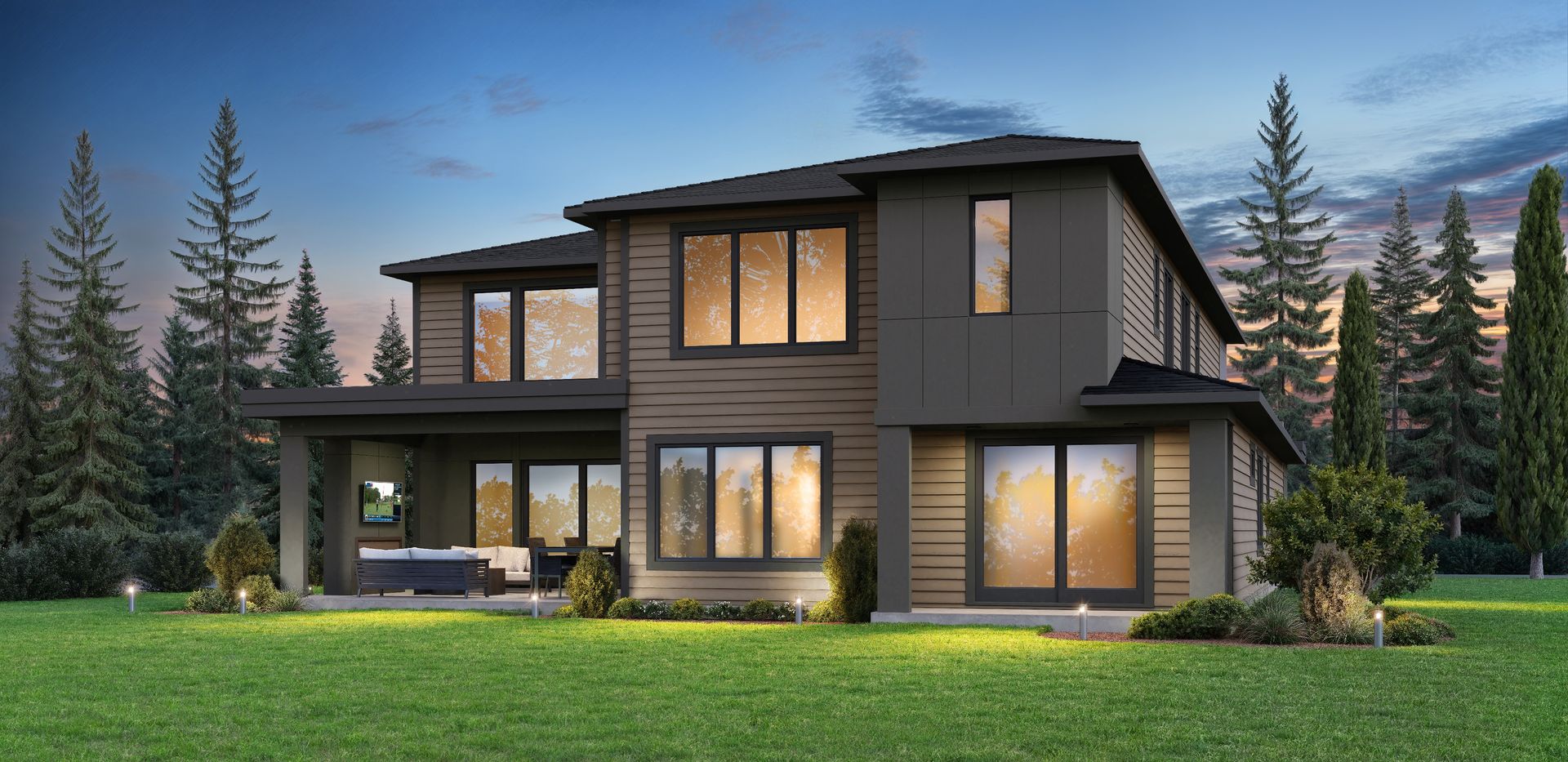 Modern two-story house with large windows, dark siding, and lit interior in a wooded yard at dusk