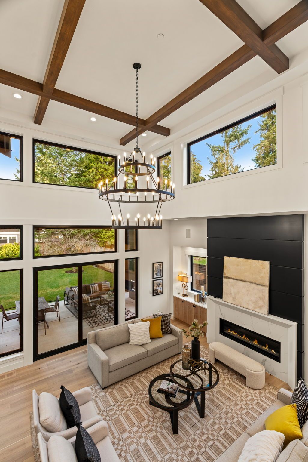 Living room with high ceilings, large windows, and a modern fireplace.