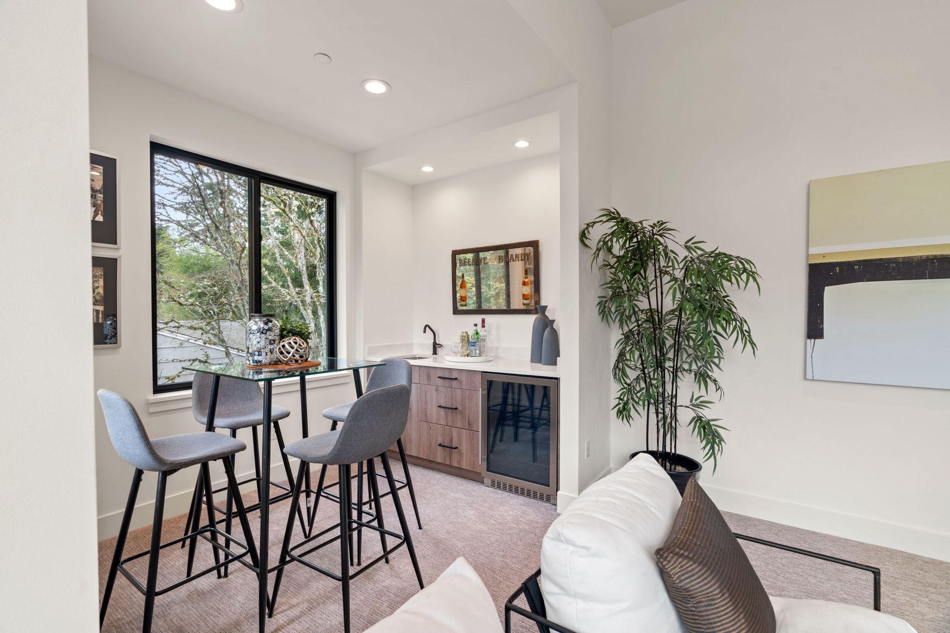 A living room with a table and chairs and a refrigerator.