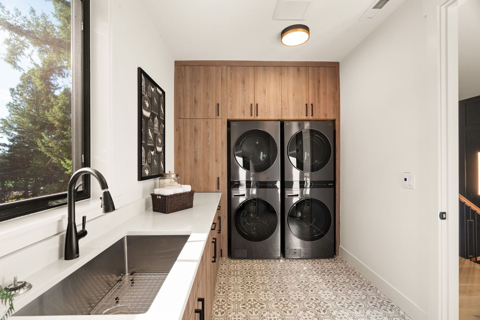 Aerial view of a residential neighborhood with a school, sports field, and city skyline in the distance.