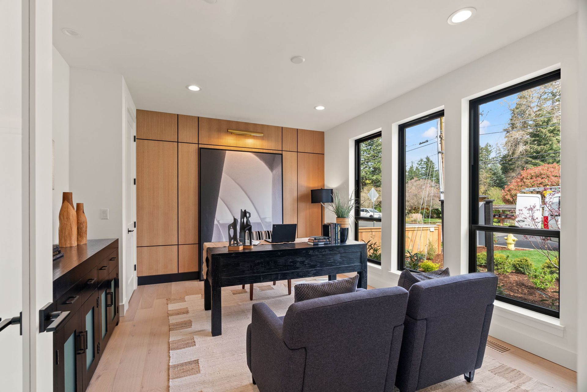 A living room with a couch , desk , chairs and windows.