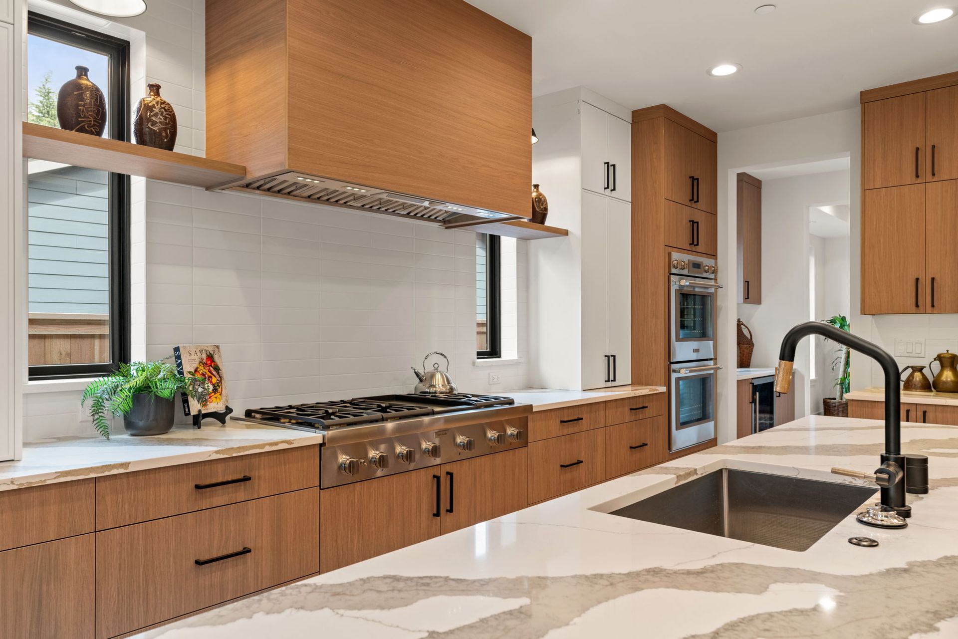 A kitchen with wooden cabinets, stainless steel appliances, a sink and a stove.