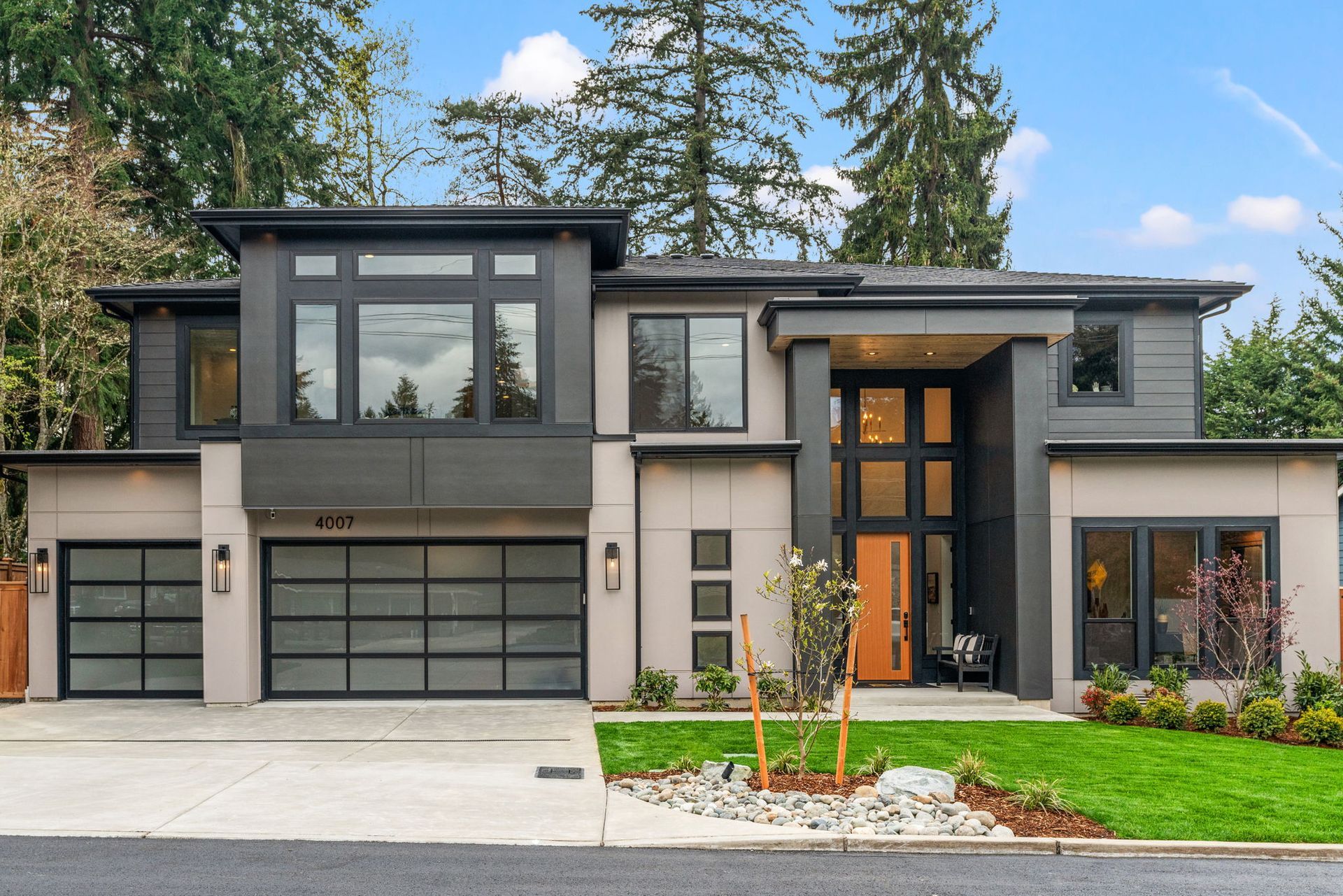 The back of a large house with a large lawn in front of it.