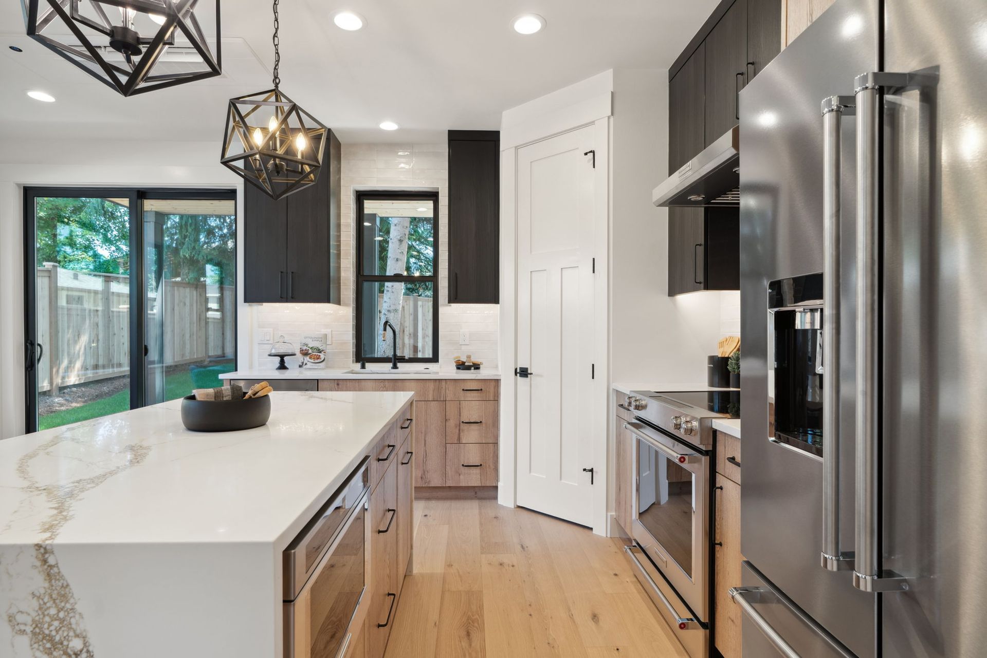 A kitchen with stainless steel appliances , wooden cabinets , and a large island.