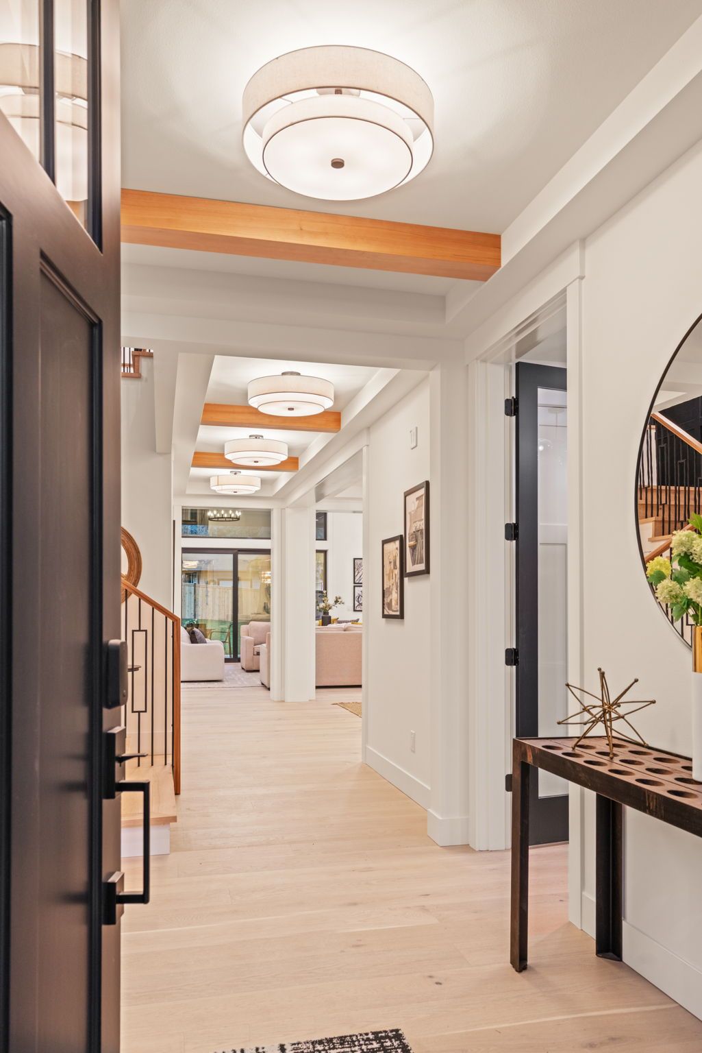 Laundry room with stacked washer/dryer, sink, wood cabinets, and window.