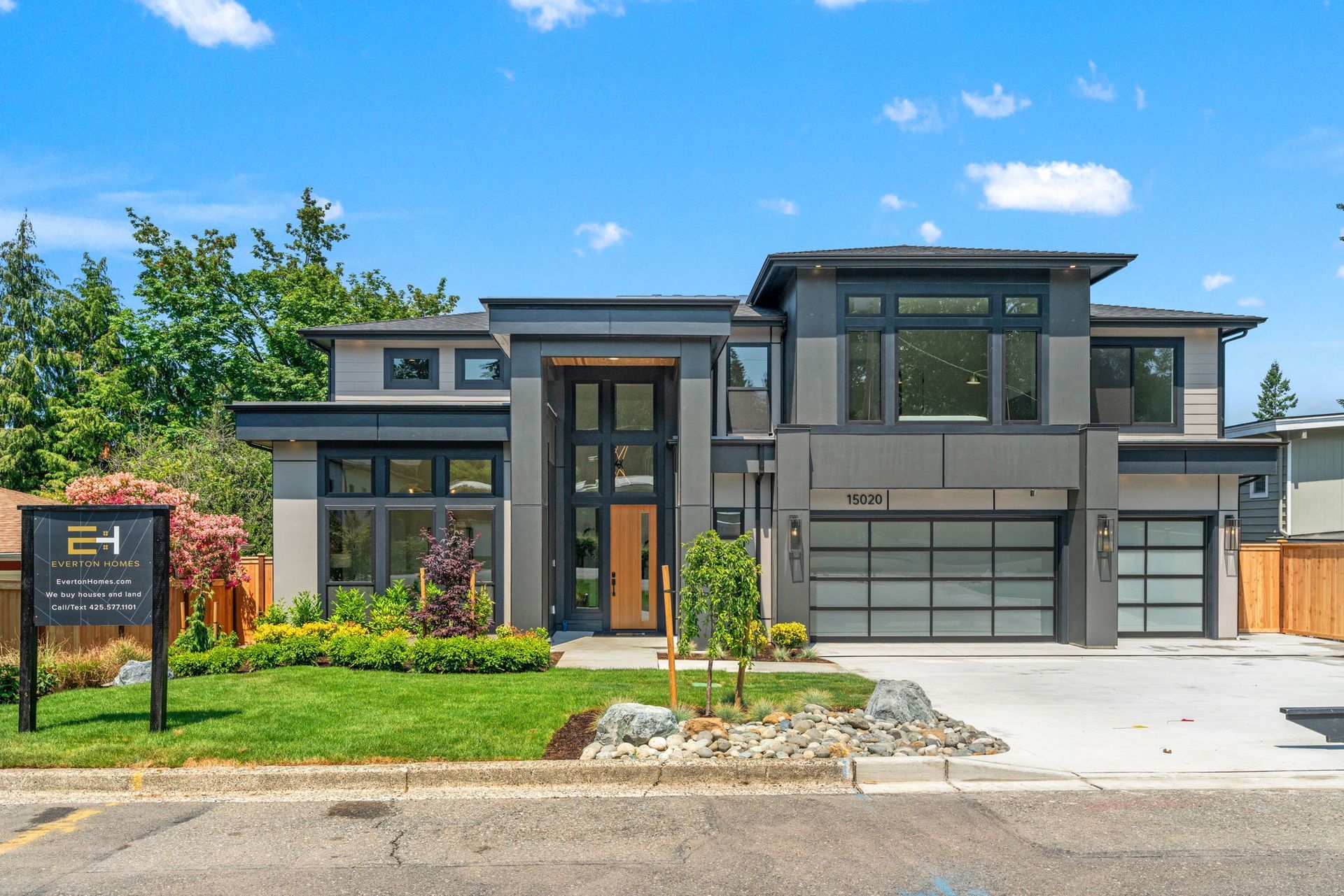 A large modern house with a sign in front of it.