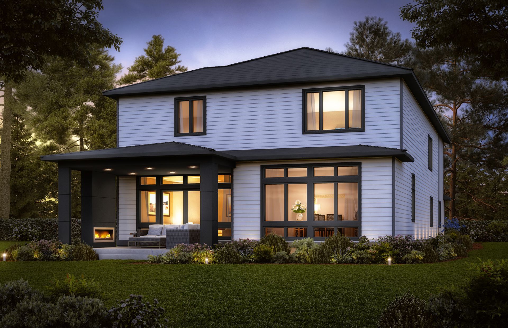 A white house with a black roof is surrounded by trees and grass.