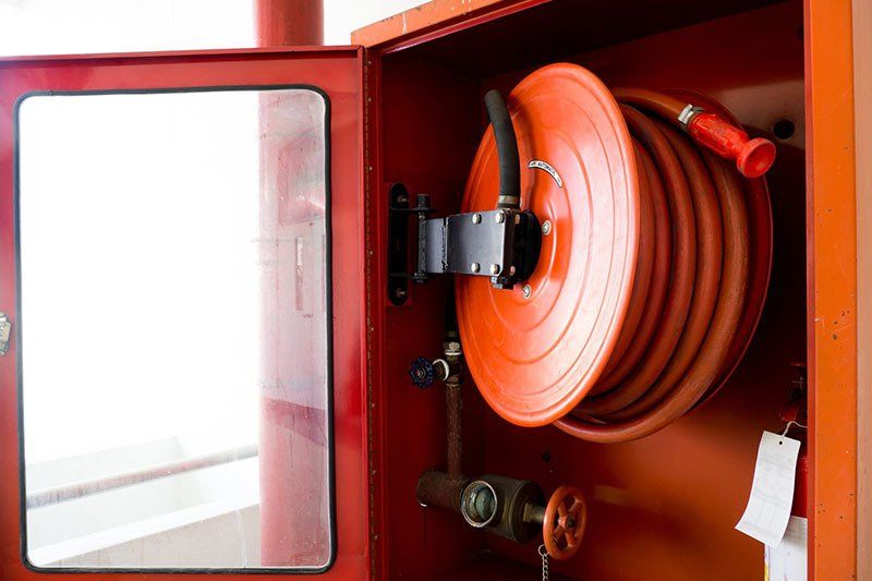 Fire Extinguishers Located In the white Wall — Safe Industries Group Newcastle NSW