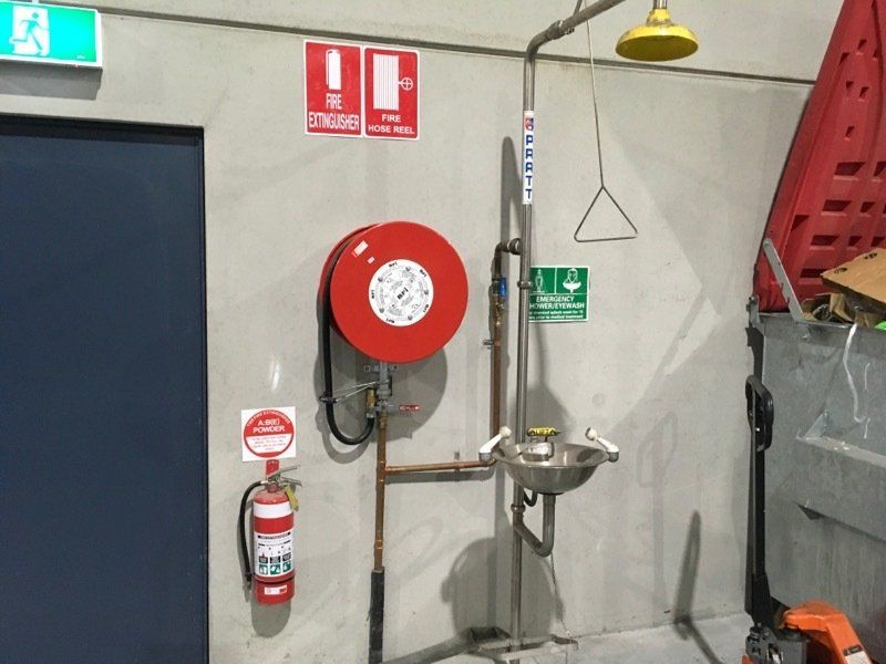 Checking Fire Extinguishers In The Building — Safe Industries Group Lake Macquarie NSW