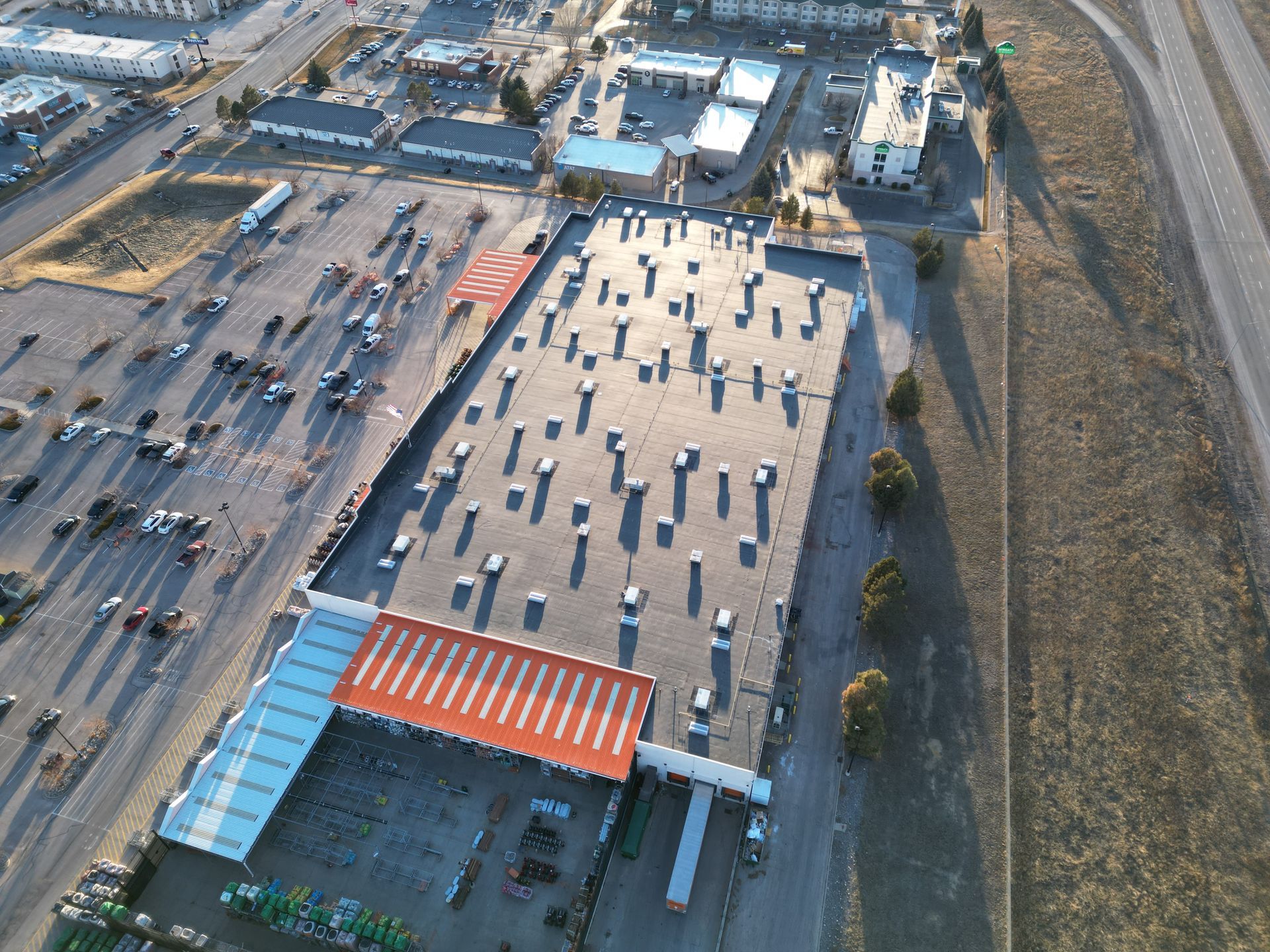 An aerial view of a large building with a lot of cars parked in front of it
