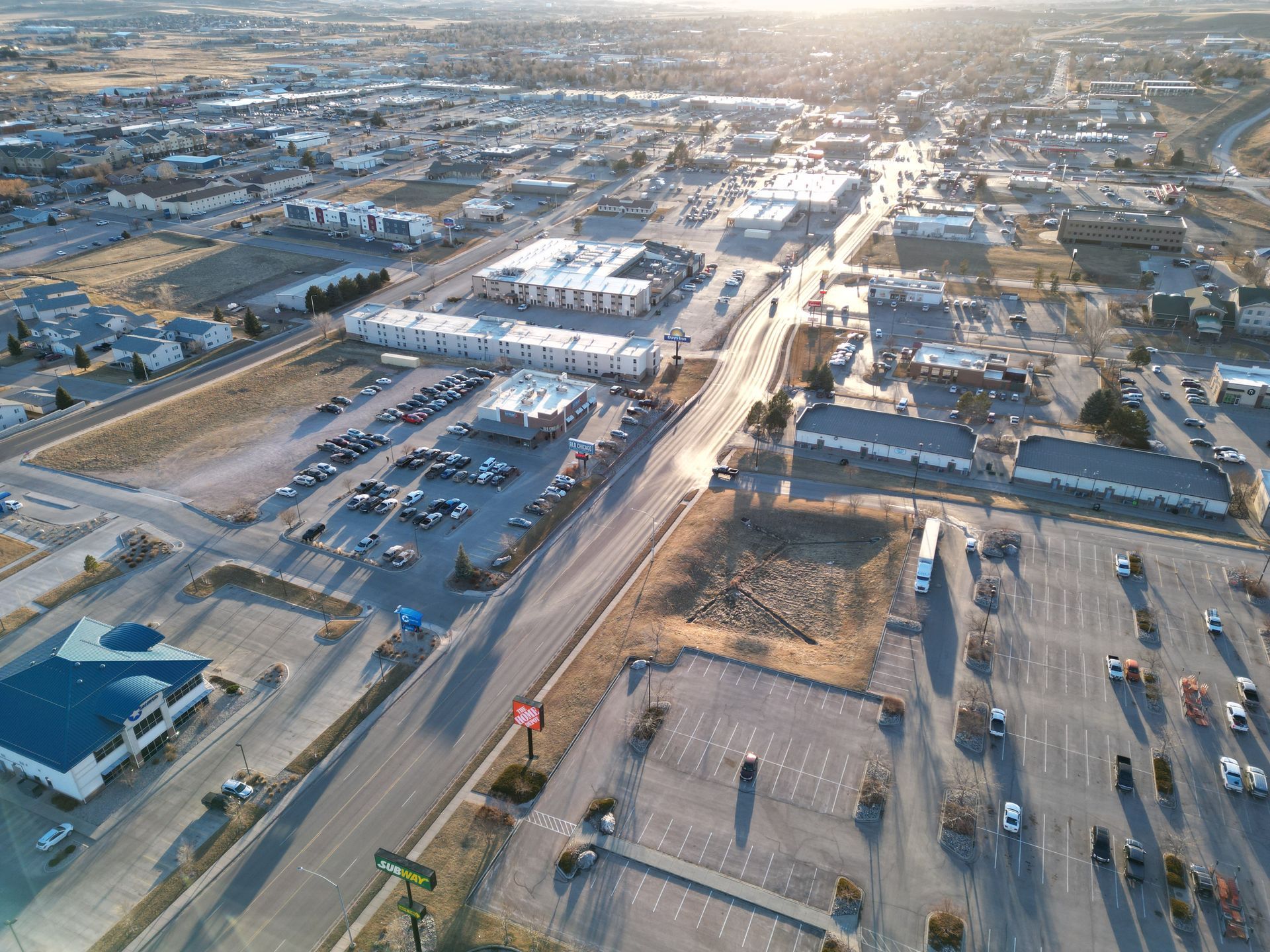 An aerial view of a city with a lot of parking lots and buildings.
