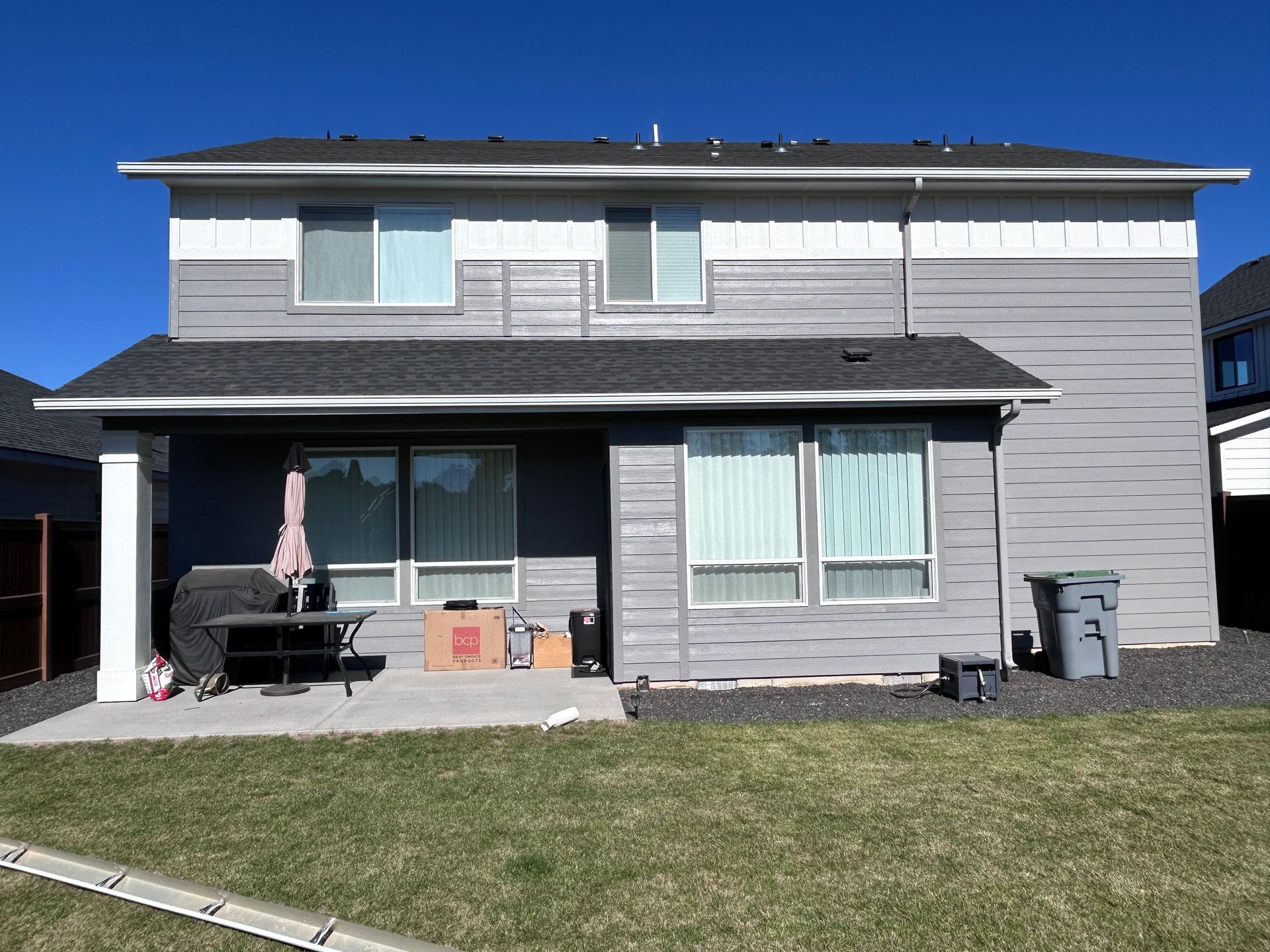 The back of a house with a lot of windows and a patio.