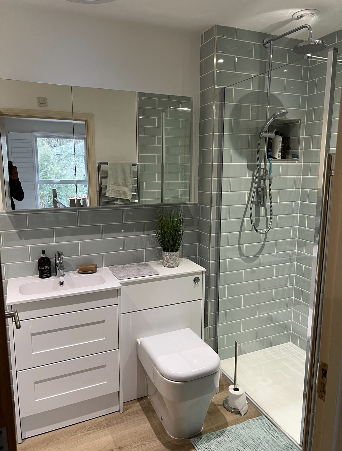 A bathroom with a toilet , sink and shower.