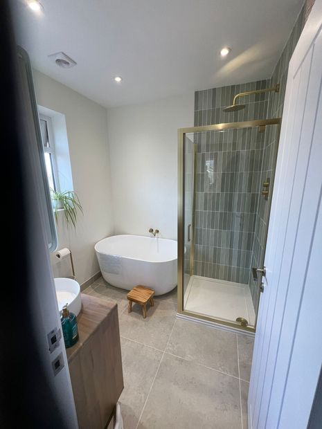 A bathroom with a bathtub , sink , toilet and mirror.
