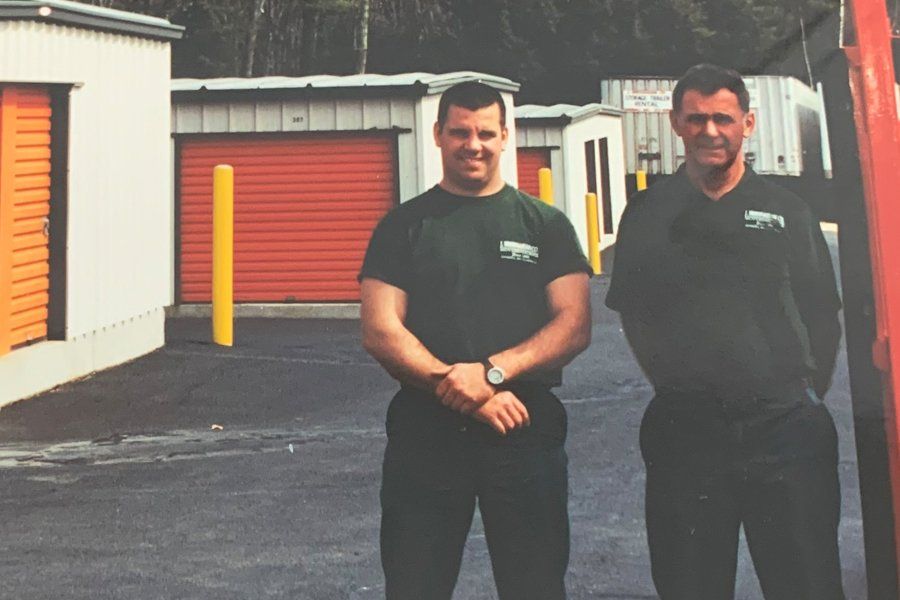Image of two men standing in front of storage units.