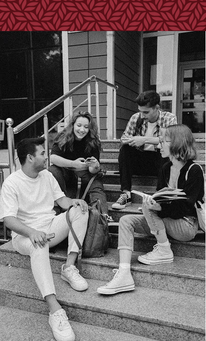 A group of young people are sitting on the steps of a building.