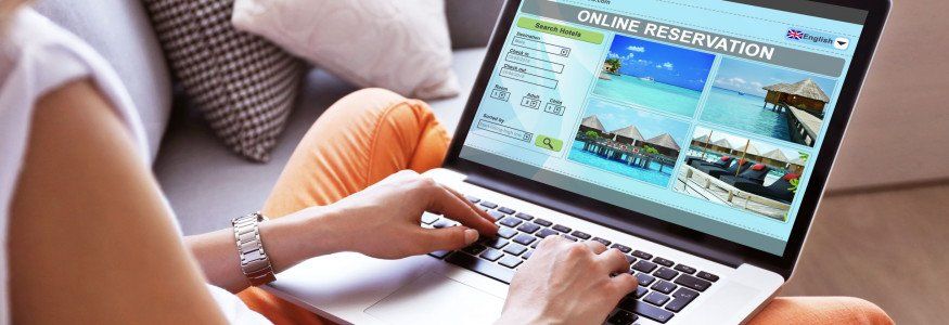 A lady making a direct booking to a hotel on a laptop