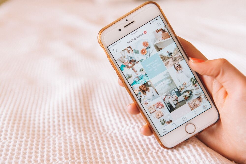 Smartphone showing a hotel's social media influencer's account being looked at by a woman