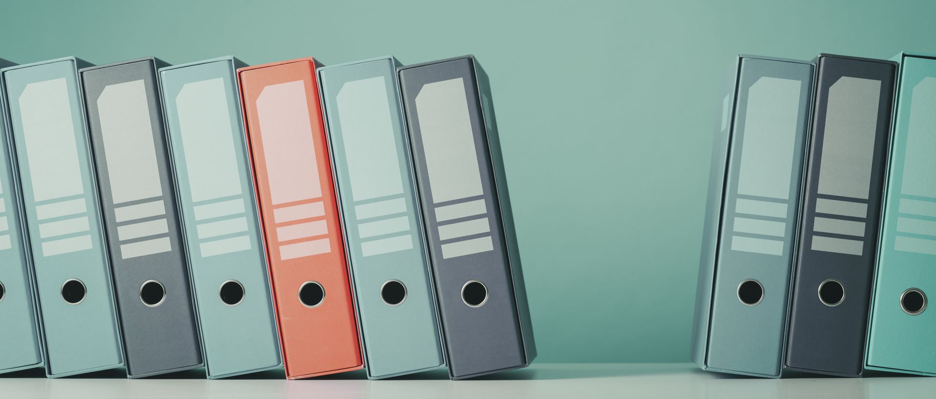 a row of binders with a red one in the middle