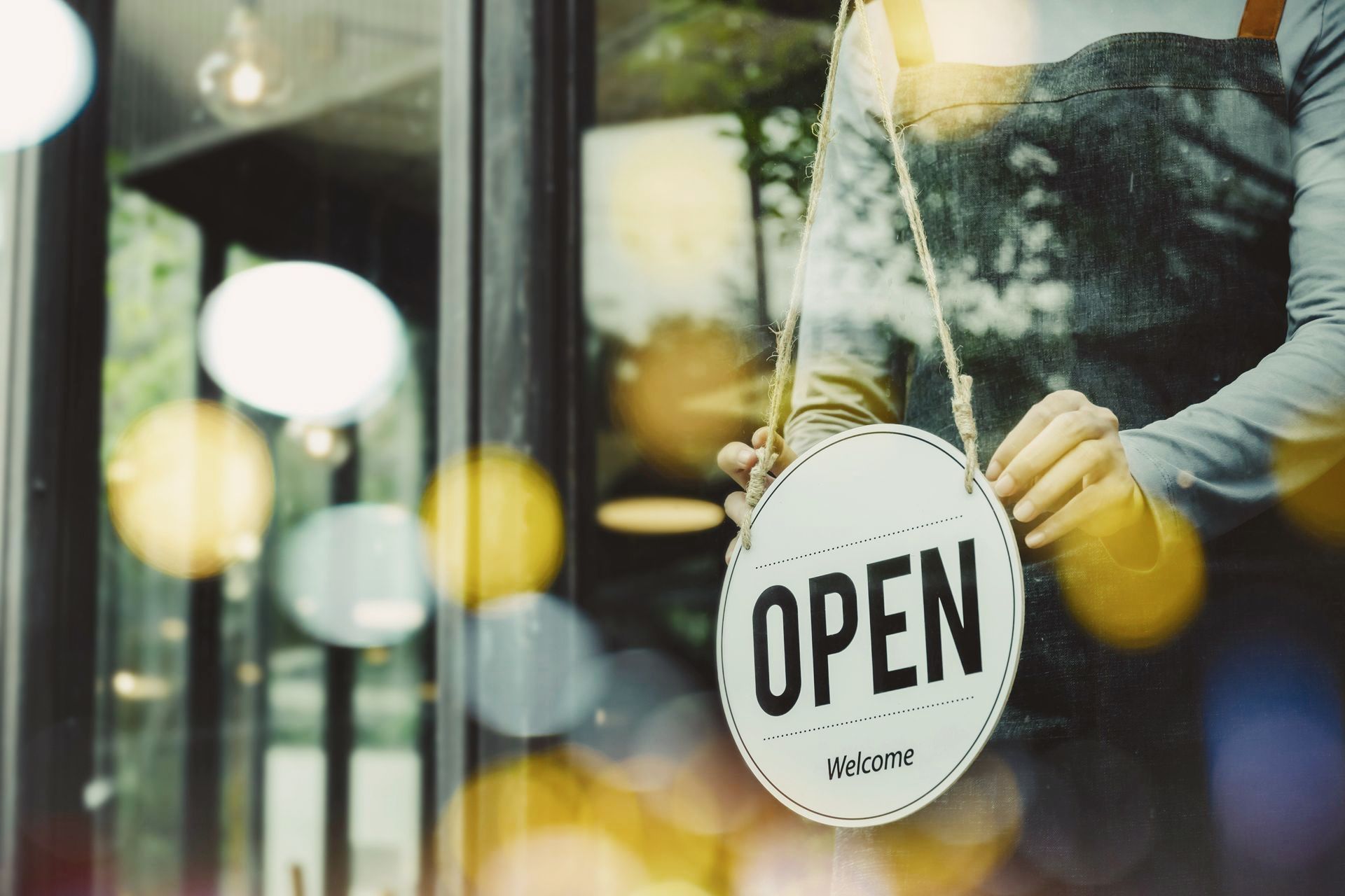a person is holding a sign that says open welcome