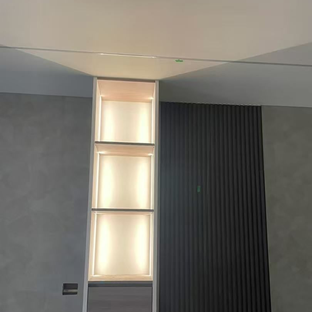 Built-in illuminated shelves against gray and dark wood paneled walls.