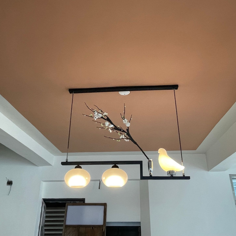 Kitchen with white cabinets, light fixtures, and a view through a window.
