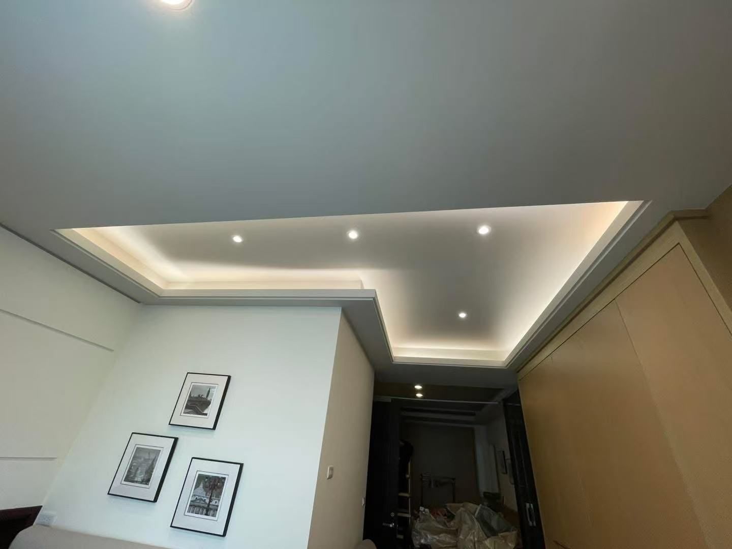Ceiling with recessed lighting and a doorway, white walls, and framed art.