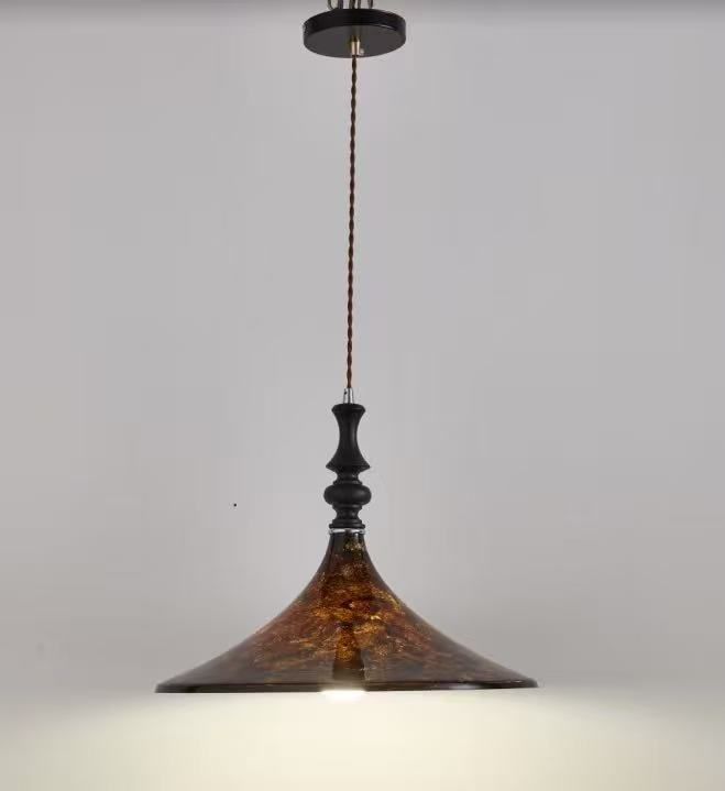 Pendant light with a brown textured shade, black accents, and a striped cord, hanging from the ceiling.