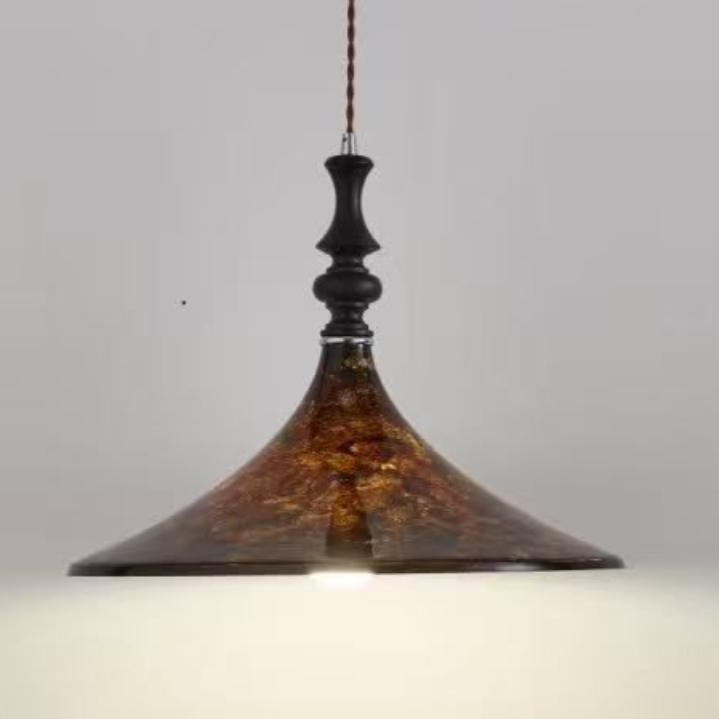 Brown and gold pendant light with a decorative, patterned shade, hanging from a ceiling.