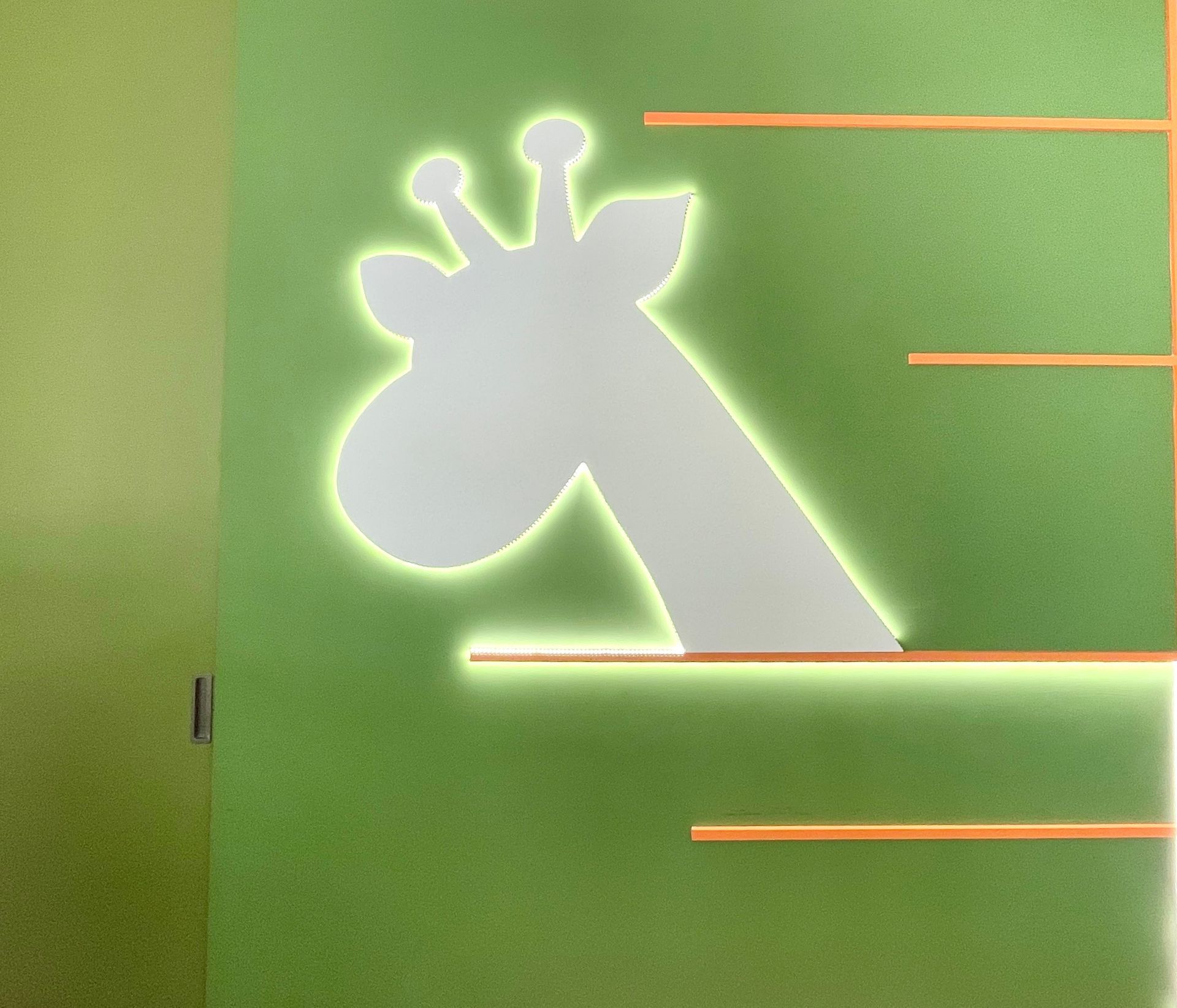 Lit building arches at night with string of lights and large tree.