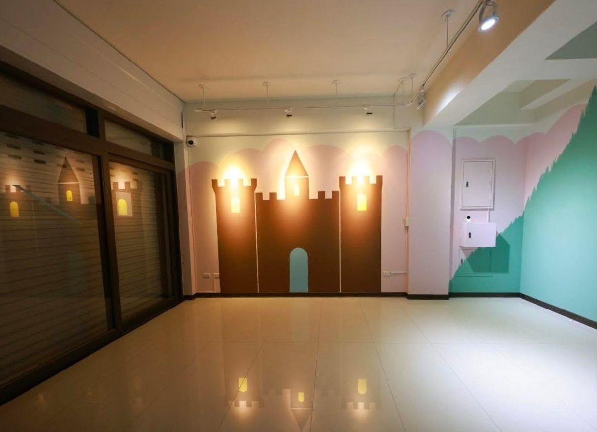 Empty room with a brown castle cutout on the wall, lit by spotlights.