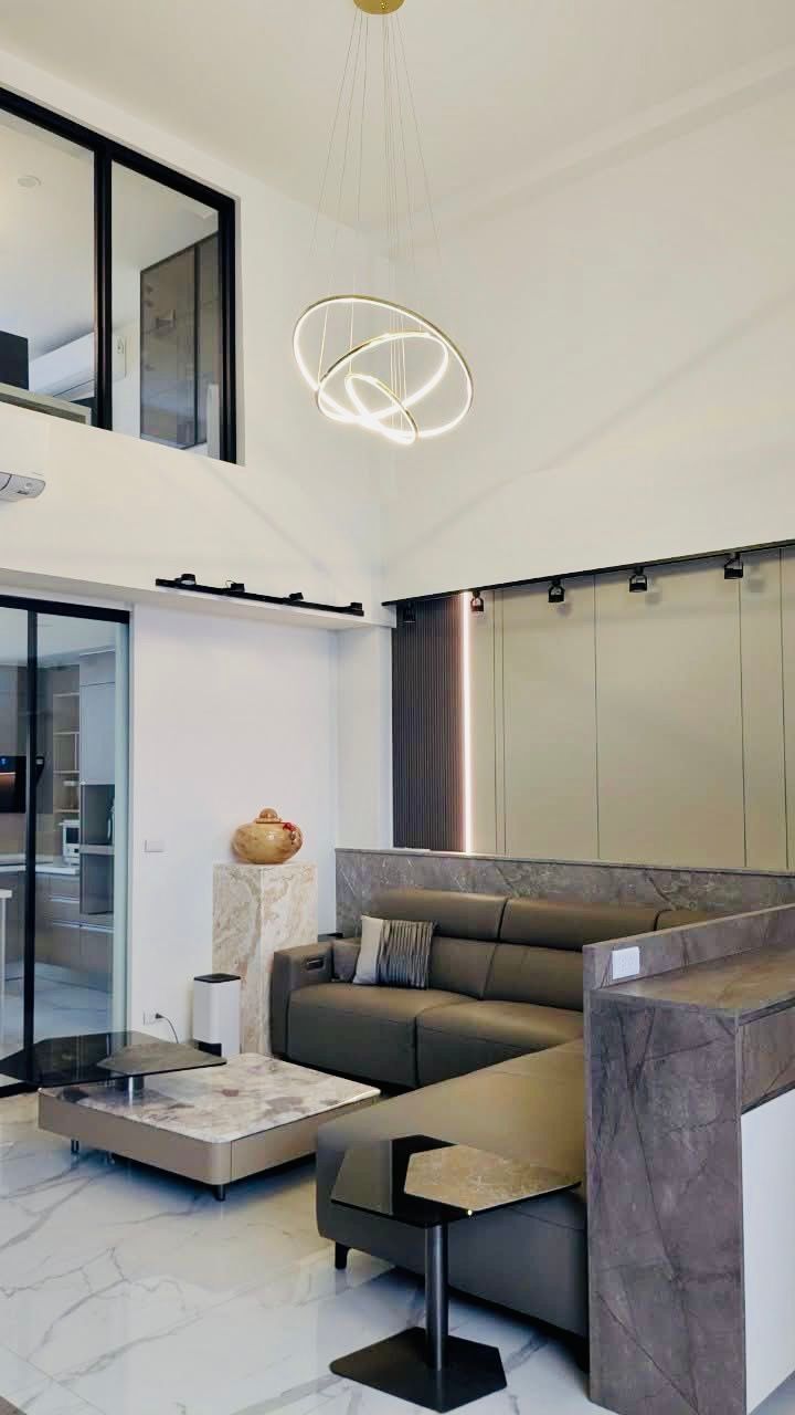 Modern living room with sectional sofa, marble floors, and decorative lighting.