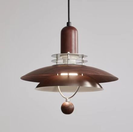 Brown and silver pendant light fixture with a spherical accent, hanging against a gray background.