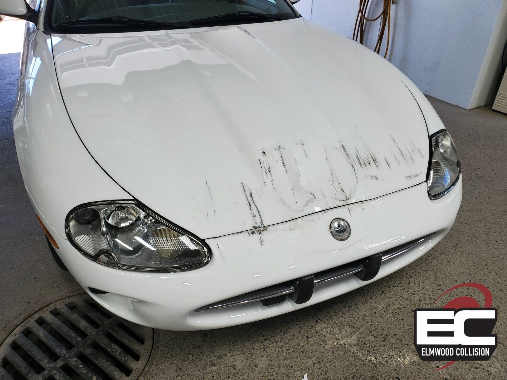 1998 Jaguar XK8 with damage to bumper and hood at Elmwood Collision in Kenmore New York