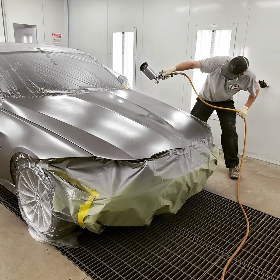 Painting the fender on vehicle in paint booth at Elmwood Collision