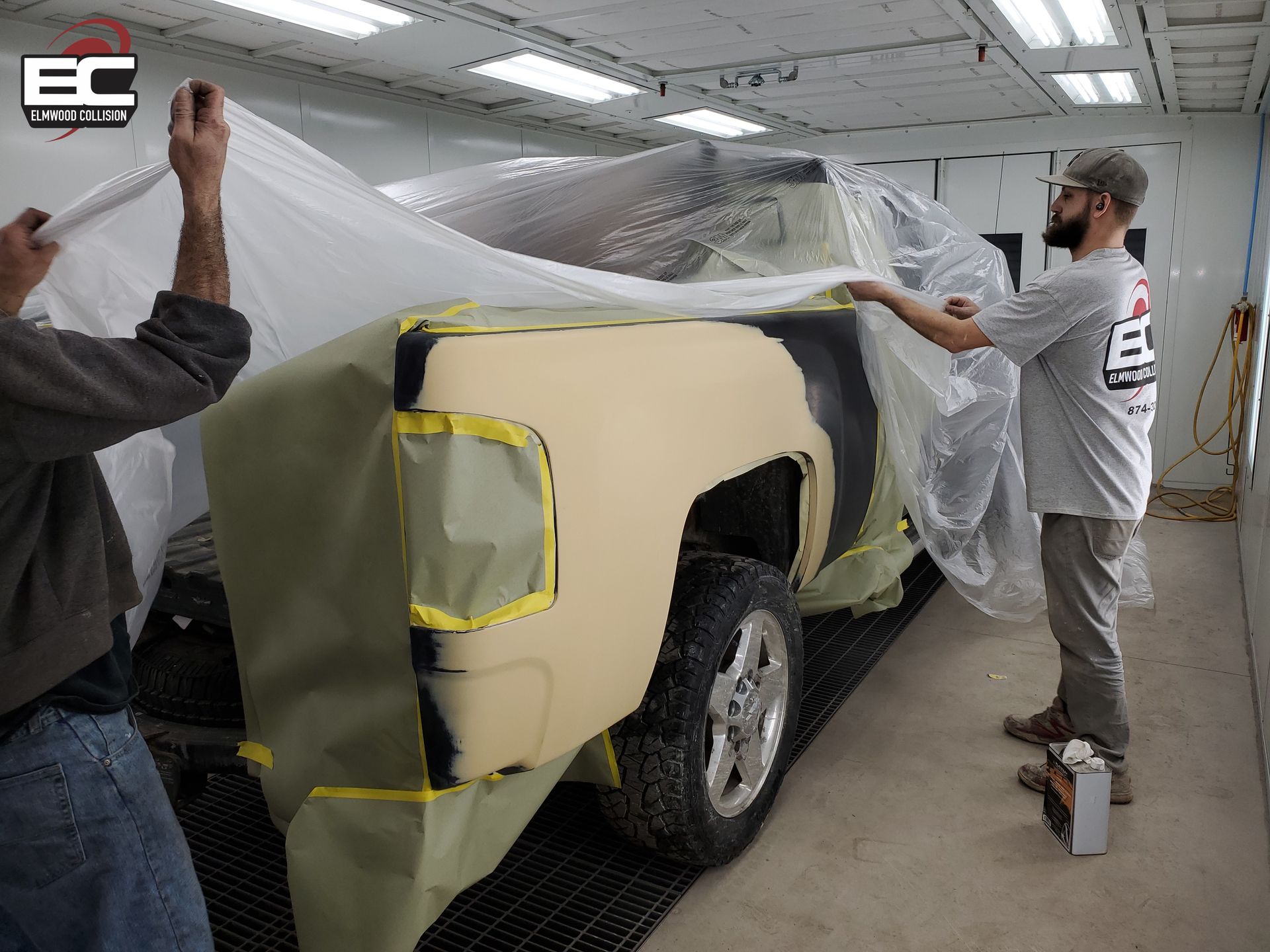Technicians wrapping vehicle before applying automotive paint at Elmwood Collision Kenmore